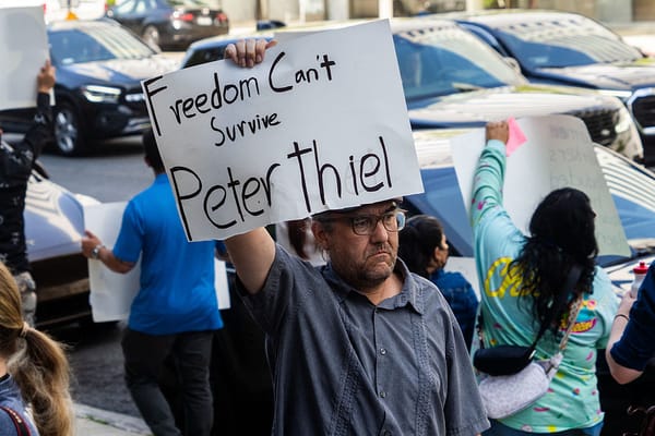 A protestor holds a sign reading Freedom Can't Survive Peter Thiel during a demonstration targeting tech billionaires on June 13 2025 in Los Angeles California USA.